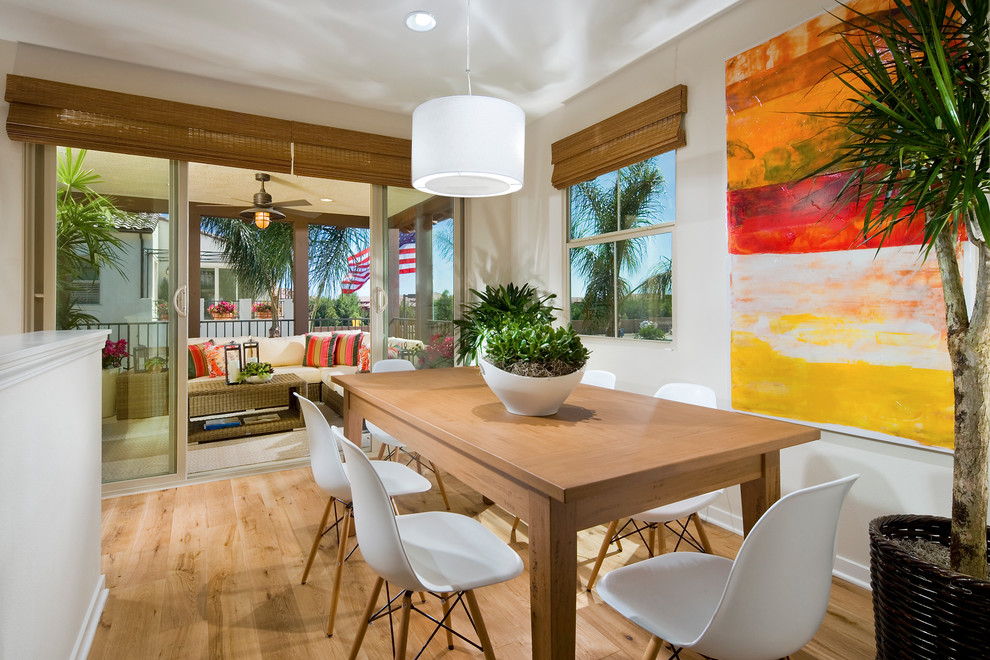 Design ideas for a contemporary dining room in Orange County with white walls and light hardwood floors.
