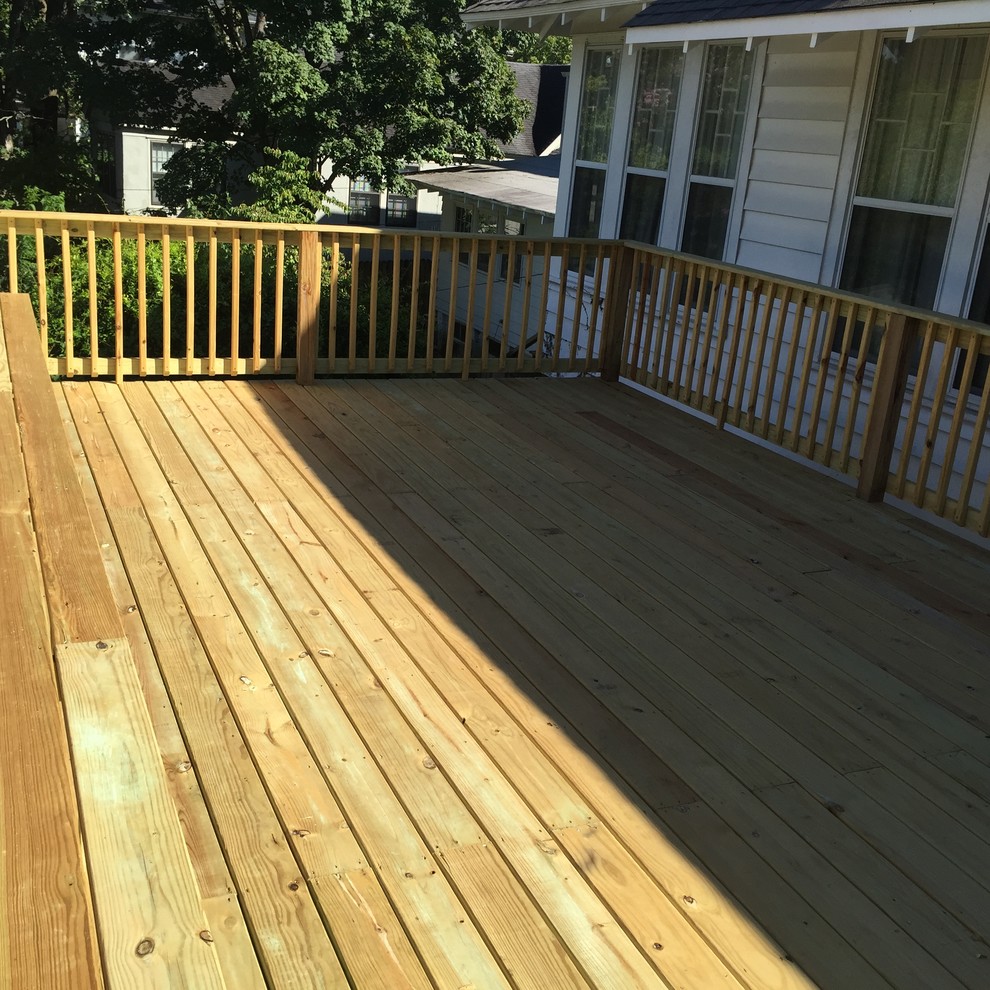 This is an example of a large country backyard deck in Little Rock with a roof extension.