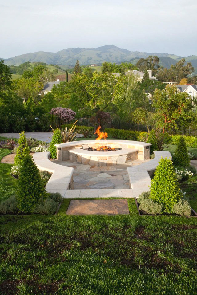 Design ideas for a large mediterranean backyard full sun formal garden for summer in San Francisco with natural stone pavers and a fire feature.