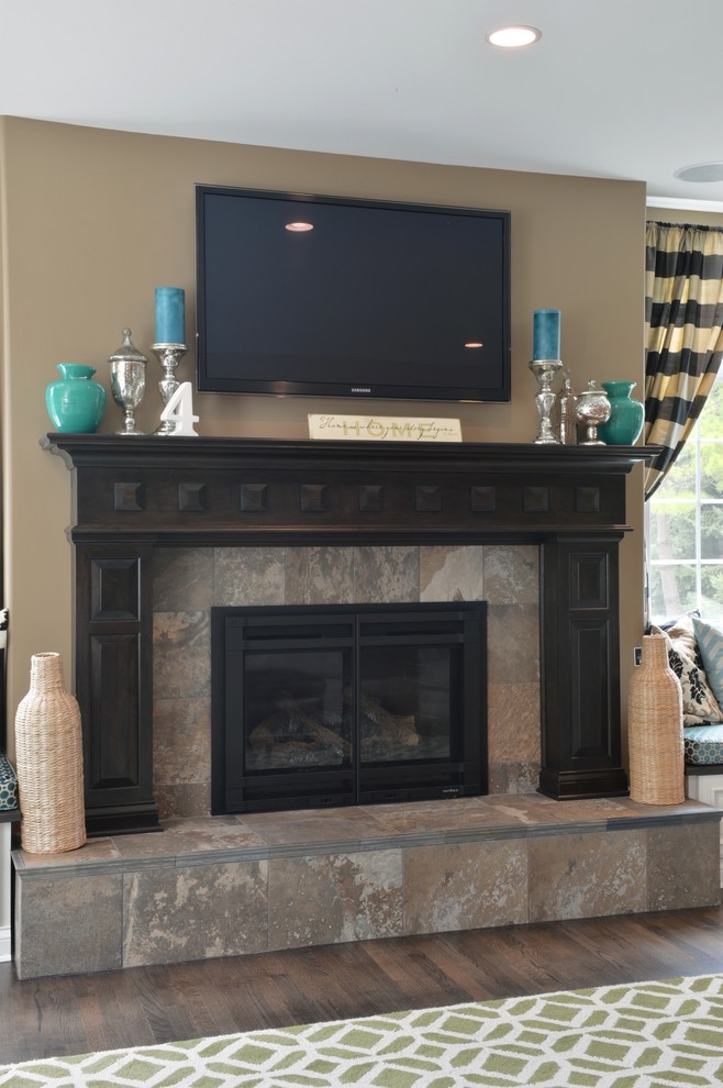 Inspiration for a large traditional living room in Milwaukee with beige walls, dark hardwood floors, a standard fireplace, a stone fireplace surround and a wall-mounted tv.