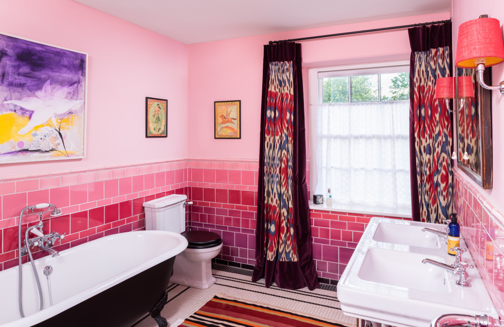 Mid-sized eclectic kids bathroom in Gloucestershire with a claw-foot tub, pink tile, porcelain tile, pink walls, mosaic tile floors, multi-coloured floor and a double vanity.