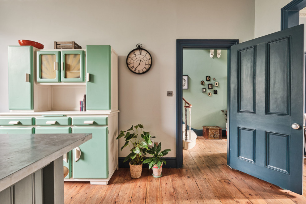 Design ideas for a large eclectic galley open plan kitchen in London with a farmhouse sink, shaker cabinets, grey cabinets, zinc benchtops, blue splashback, ceramic splashback, coloured appliances, medium hardwood floors, with island and grey benchtop.