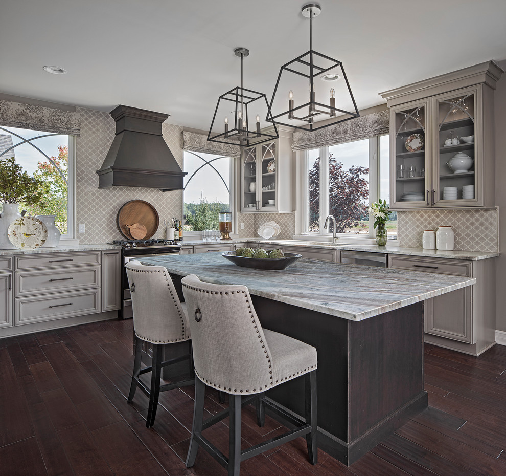 Inspiration for a transitional l-shaped brown floor and dark wood floor eat-in kitchen remodel with glass-front cabinets, gray cabinets, stainless steel appliances, an island, an undermount sink and gray backsplash