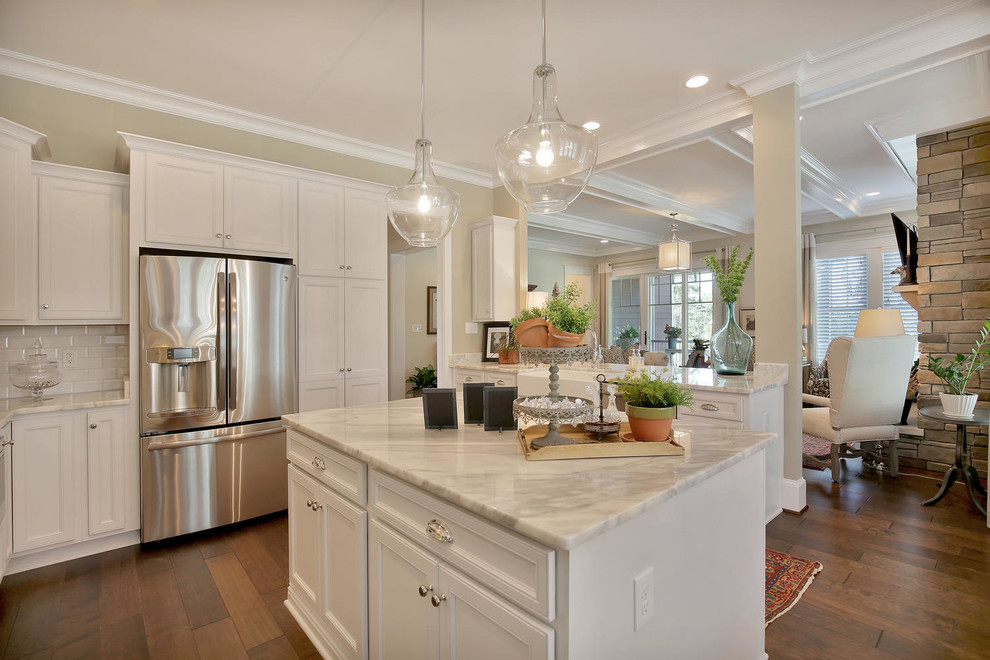 This is an example of a mid-sized traditional l-shaped eat-in kitchen in Richmond with a farmhouse sink, recessed-panel cabinets, white cabinets, stainless steel appliances, dark hardwood floors and with island.