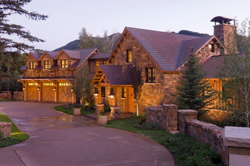 Expansive arts and crafts two-storey brown house exterior in Denver with stone veneer and a shingle roof.
