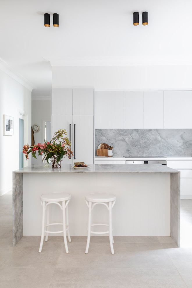 Photo of a mid-sized modern l-shaped open plan kitchen in Sydney with an undermount sink, white cabinets, marble benchtops, grey splashback, marble splashback, stainless steel appliances, ceramic floors, with island, beige floor and grey benchtop.