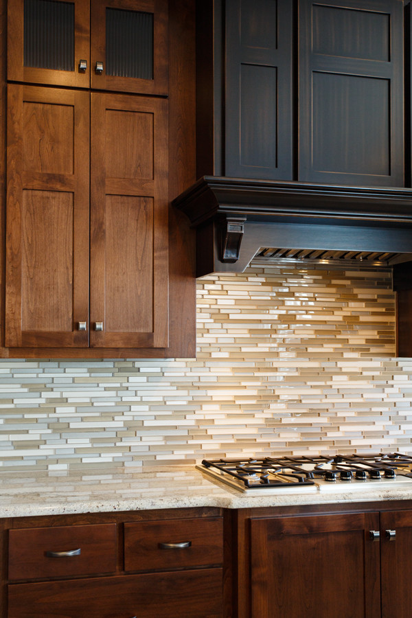 Inspiration for a large transitional u-shaped eat-in kitchen remodel with recessed-panel cabinets, dark wood cabinets, granite countertops, multicolored backsplash, glass tile backsplash, colored appliances and an island