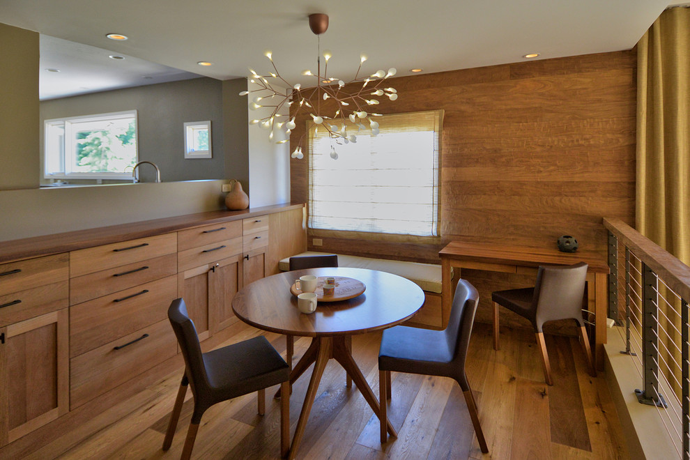 Photo of a midcentury dining room in San Francisco with dark hardwood floors.