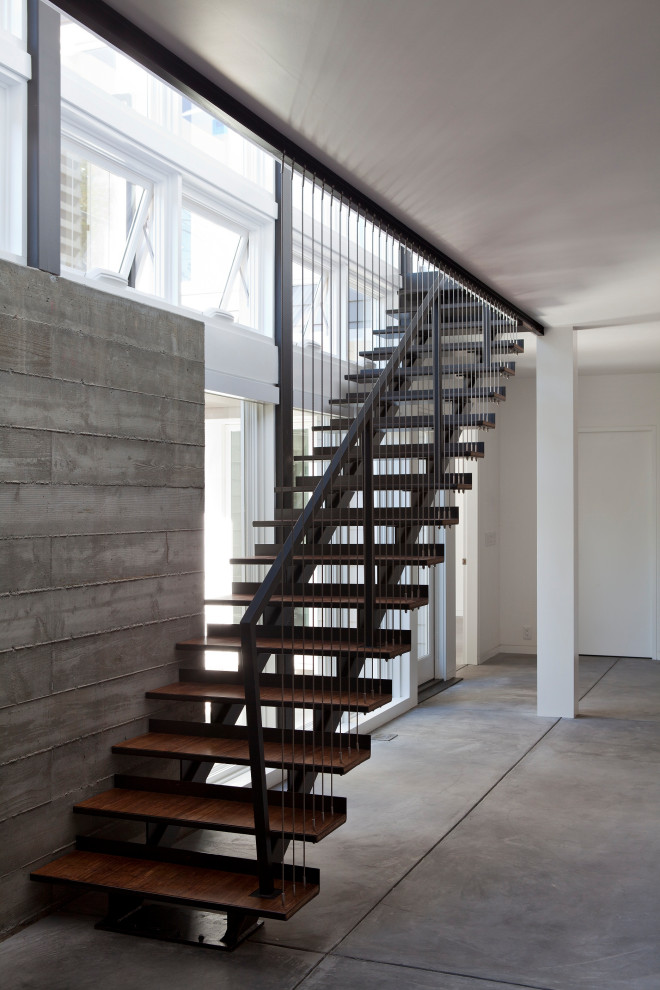 This is an example of a contemporary wood straight staircase in San Francisco with metal risers and metal railing.