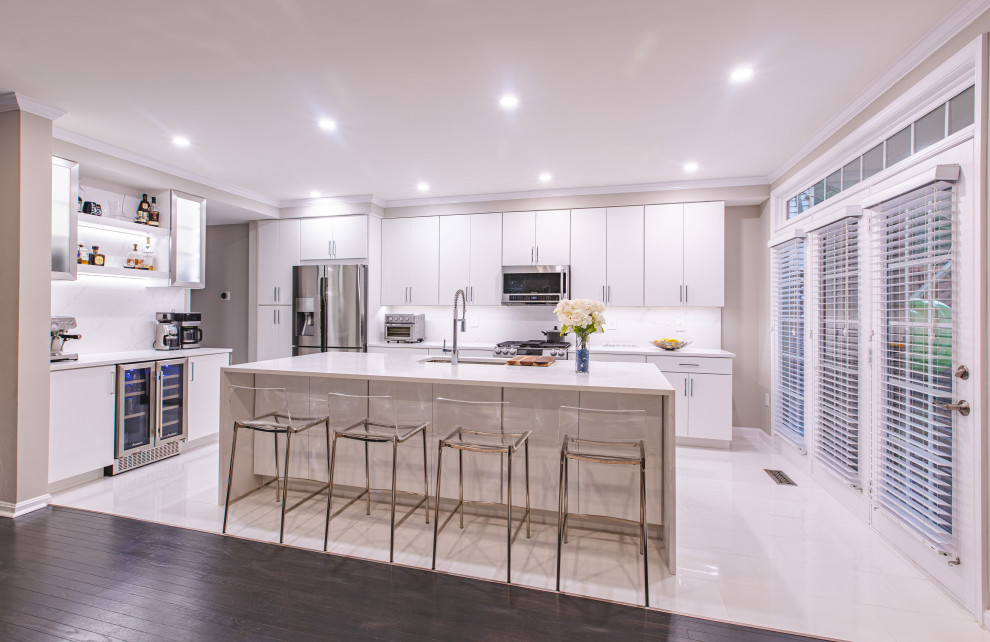 Contemporary eat-in kitchen in DC Metro with a drop-in sink, beige splashback, stainless steel appliances, multiple islands and white benchtop.