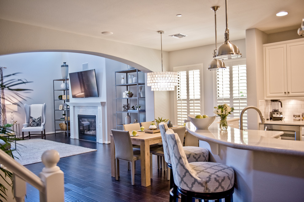 Example of a large transitional u-shaped dark wood floor open concept kitchen design in Phoenix with recessed-panel cabinets, white cabinets, marble countertops, white backsplash, an island, a drop-in sink, subway tile backsplash and stainless steel appliances