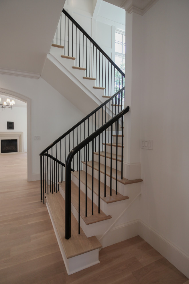 Свежая идея для дизайна: большая п-образная лестница в стиле модернизм с деревянными ступенями, крашенными деревянными подступенками, перилами из смешанных материалов и панелями на стенах - отличное фото интерьера