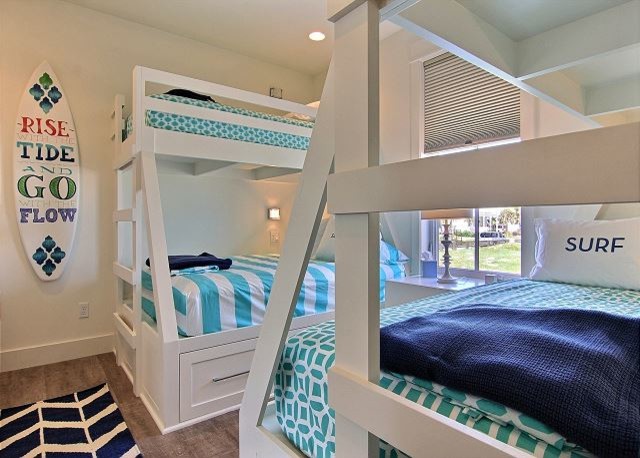 This is an example of a small beach style guest bedroom in Austin with white walls, medium hardwood floors and brown floor.