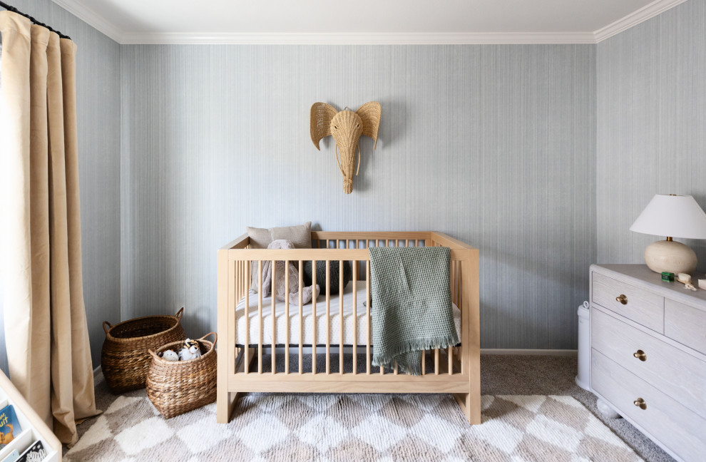 Foto di una piccola cameretta per neonato tradizionale con pareti blu e carta da parati