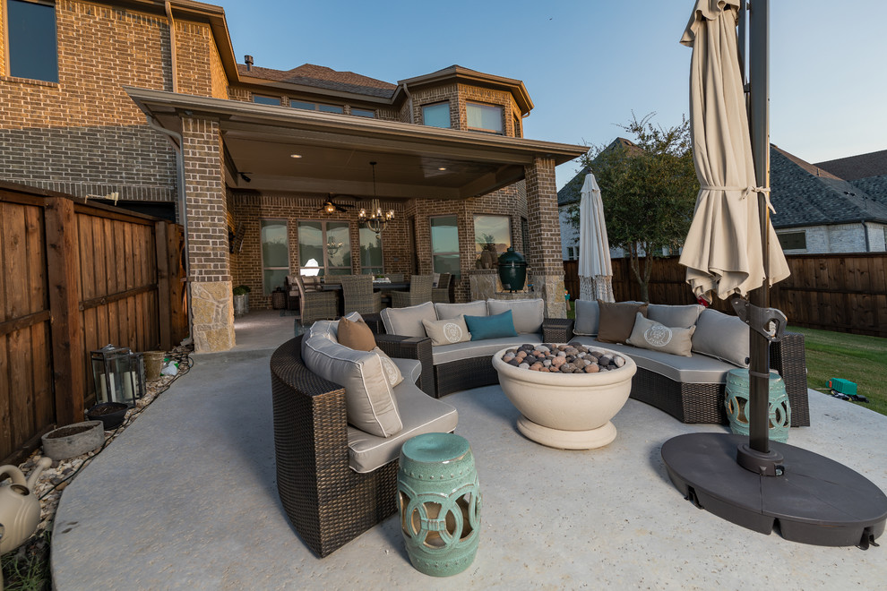 Mid-sized transitional backyard patio in Dallas with a fire feature, concrete slab and a roof extension.