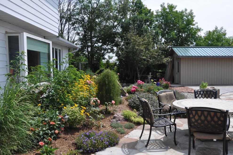 Inspiration for a large transitional backyard stone landscaping in Ottawa.