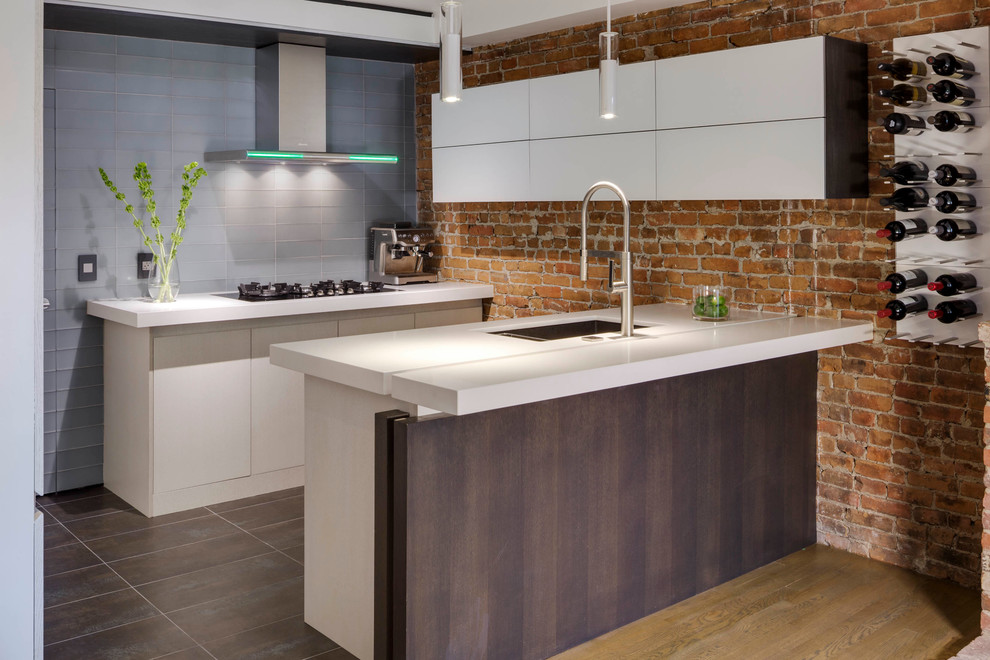 Inspiration for a small contemporary u-shaped eat-in kitchen in Boston with flat-panel cabinets, an undermount sink, white cabinets, black appliances, a peninsula, solid surface benchtops, red splashback and porcelain floors.
