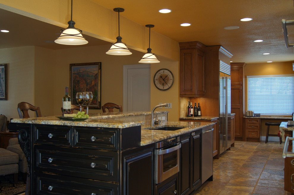 Design ideas for a mid-sized mediterranean galley eat-in kitchen in Denver with an undermount sink, raised-panel cabinets, black cabinets, granite benchtops, stainless steel appliances, ceramic floors and with island.