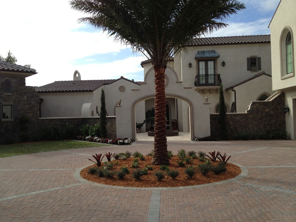 Expansive mediterranean two-storey beige exterior in Tampa with stone veneer and a gable roof.
