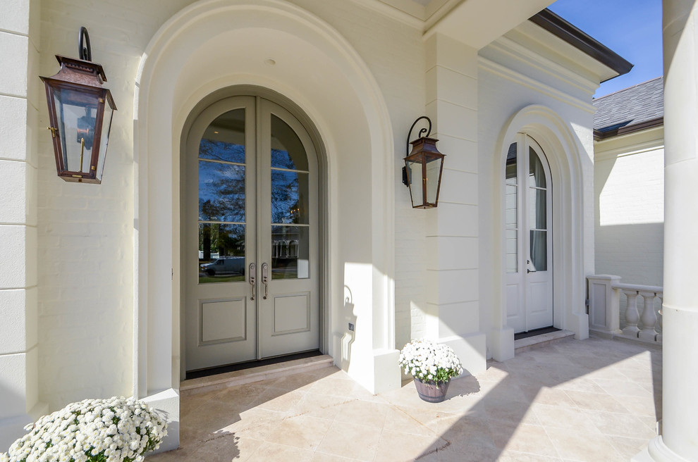 Photo of a large traditional one-storey white exterior in New Orleans with stone veneer and a gable roof.
