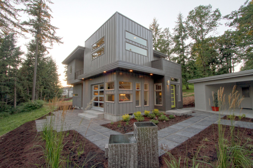 This is an example of a mid-sized modern two-storey grey exterior in Portland with mixed siding and a flat roof.