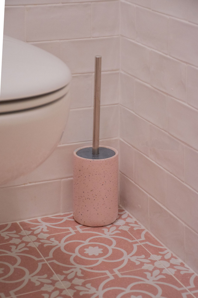 Esempio di una stanza da bagno padronale moderna di medie dimensioni con WC sospeso, piastrelle bianche, piastrelle in ceramica, pareti bianche, pavimento in cementine, lavabo a consolle, pavimento rosa, porta doccia scorrevole e un lavabo