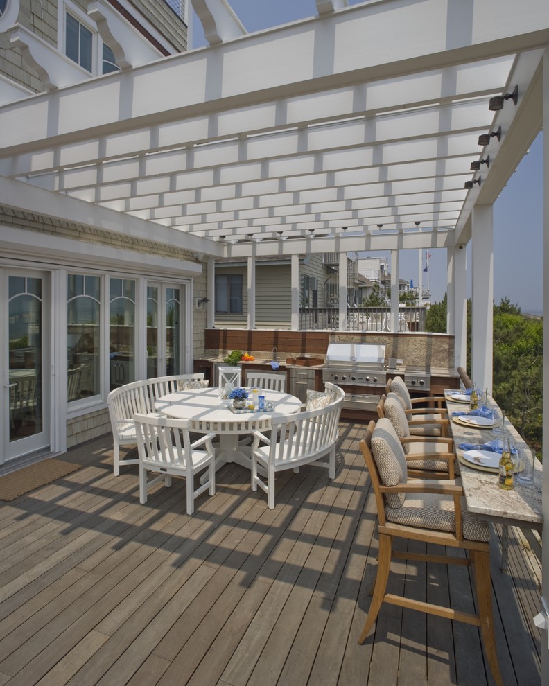 Design ideas for a large beach style backyard deck in Philadelphia with a pergola.
