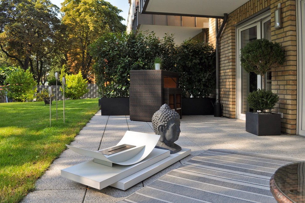 Mittelgroße Moderne Terrasse neben dem Haus, im Erdgeschoss mit Feuerstelle und Markisen in Sonstige