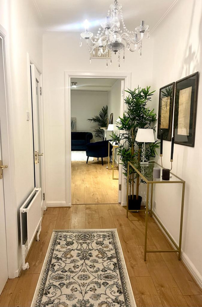 This is an example of a mid-sized modern hallway in London with white walls, laminate floors, beige floor, recessed and wallpaper.