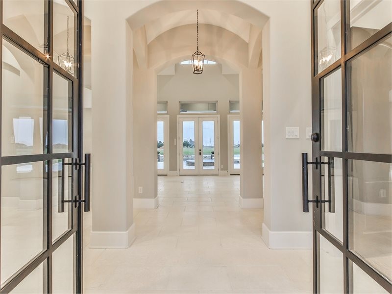 Design ideas for a large transitional hallway in Houston with beige walls, limestone floors and beige floor.