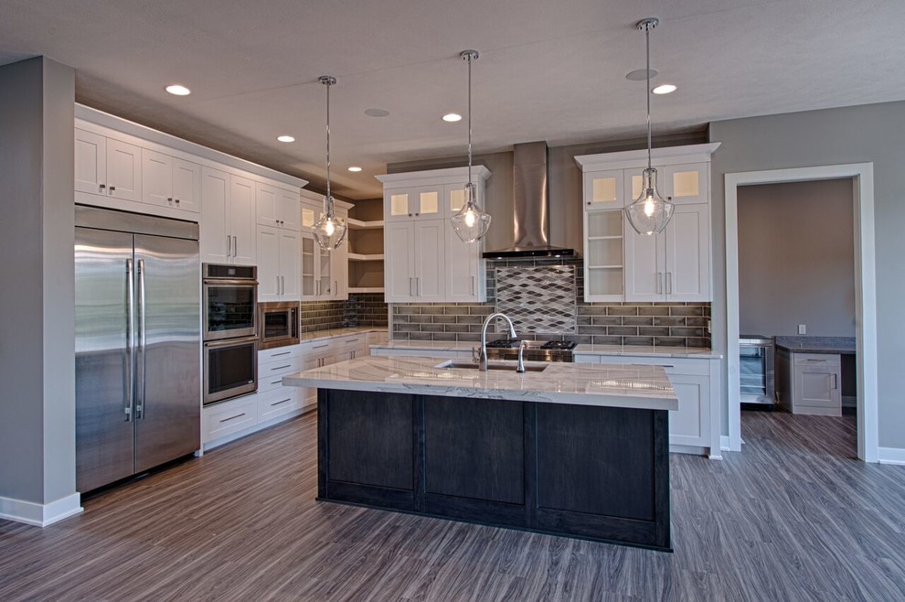Large transitional galley vinyl floor and gray floor eat-in kitchen photo with a single-bowl sink, shaker cabinets, white cabinets, quartzite countertops, gray backsplash, ceramic backsplash, stainless steel appliances and an island