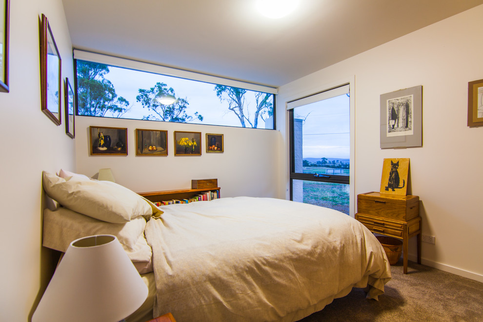 This is an example of a small transitional master bedroom in Hobart with white walls, carpet and no fireplace.