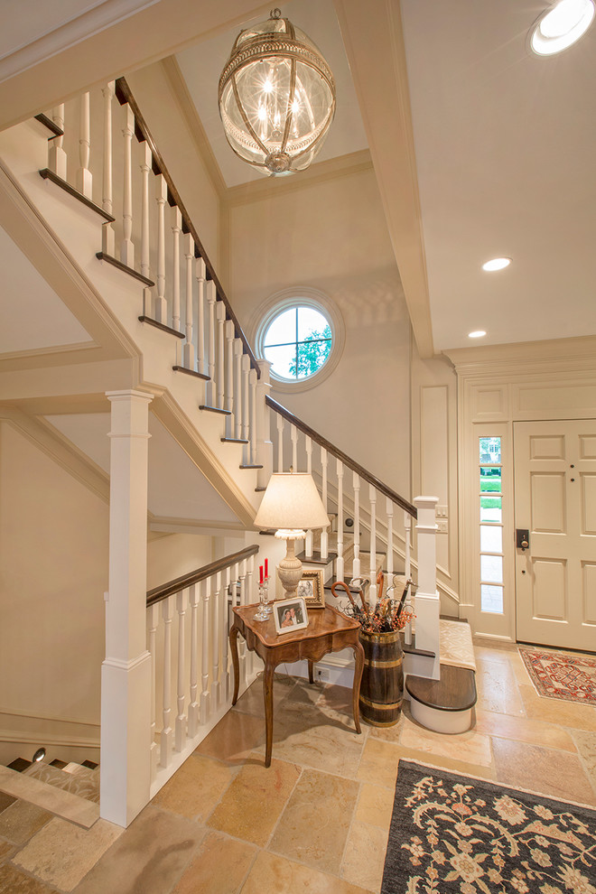 This is an example of a traditional foyer in Omaha with a single front door, a white front door and beige floor.