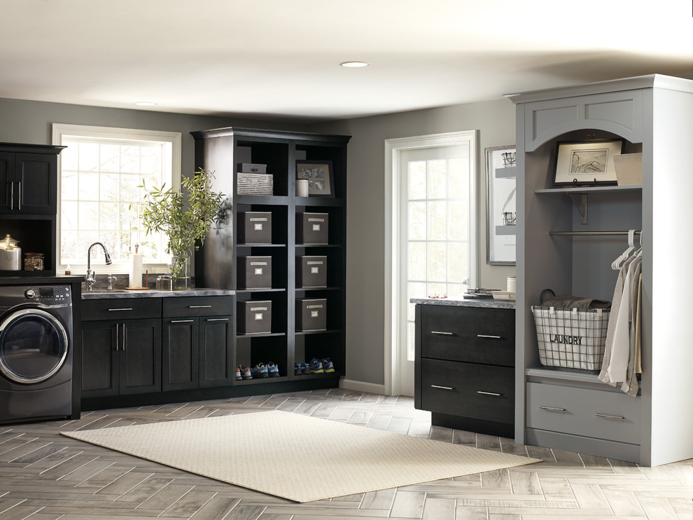 Design ideas for an expansive transitional single-wall dedicated laundry room in Atlanta with an undermount sink, shaker cabinets, black cabinets, granite benchtops, grey walls, medium hardwood floors, a side-by-side washer and dryer and grey floor.
