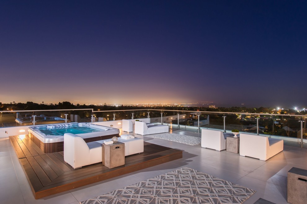 This is an example of an expansive contemporary rooftop deck in Los Angeles with a water feature and no cover.