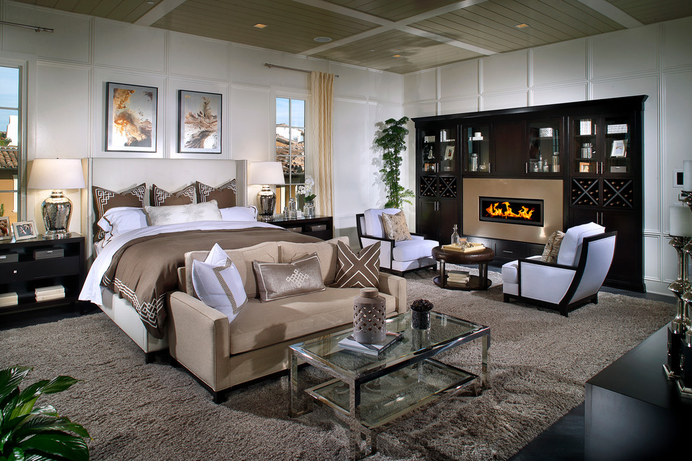 This is an example of an expansive contemporary master bedroom in San Diego with white walls, dark hardwood floors, a ribbon fireplace and a metal fireplace surround.