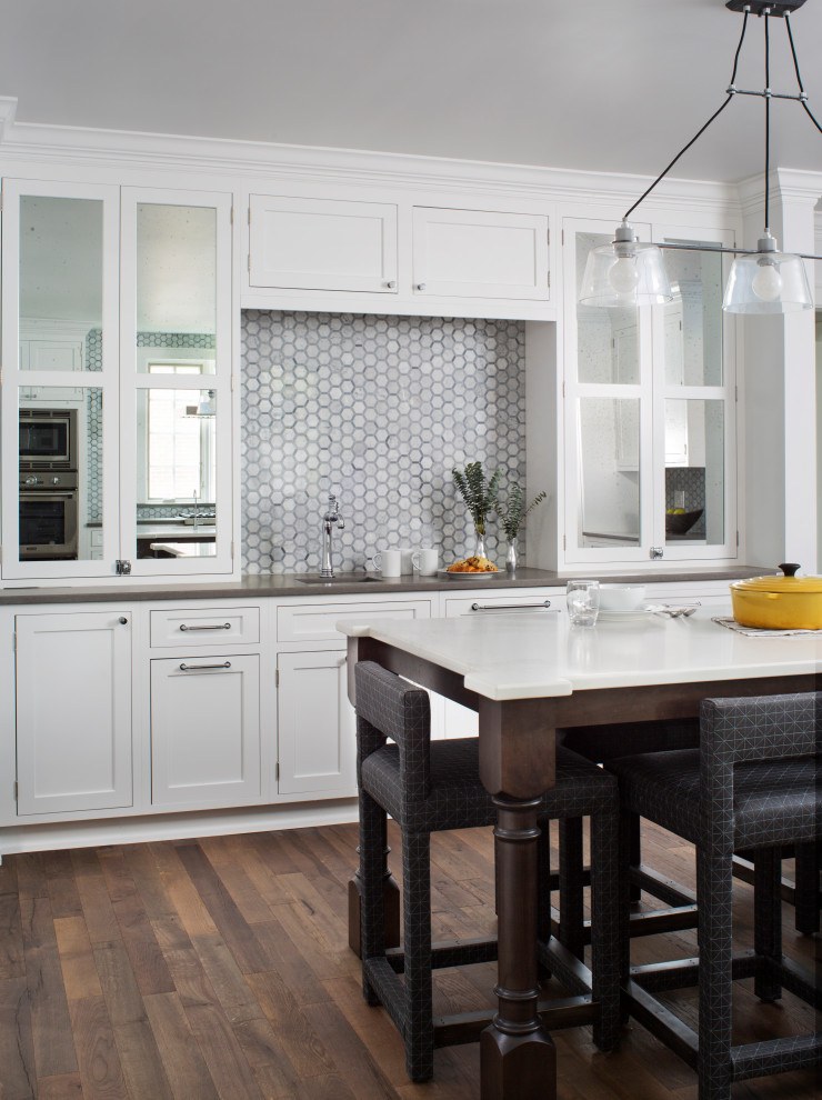 Eat-in kitchen - large transitional l-shaped medium tone wood floor and brown floor eat-in kitchen idea in Chicago with a double-bowl sink, recessed-panel cabinets, solid surface countertops, gray backsplash, glass tile backsplash, stainless steel appliances, two islands and white countertops