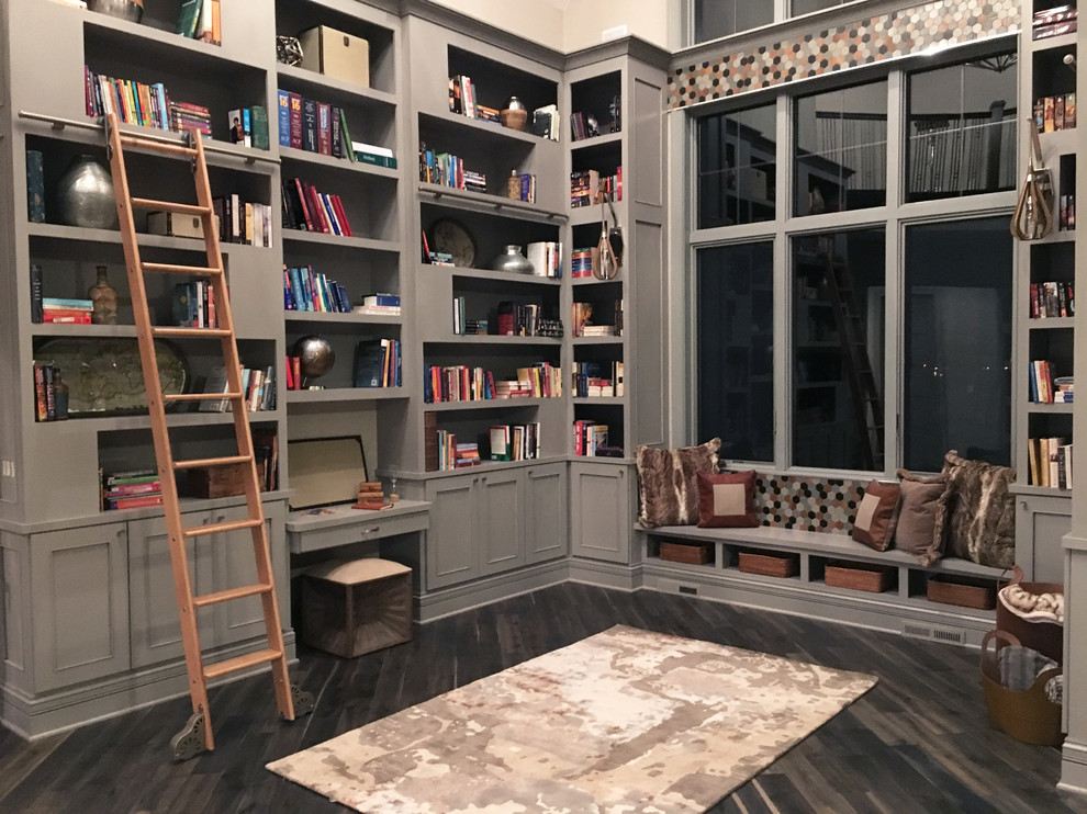 Design ideas for an expansive transitional home office in Milwaukee with a library, dark hardwood floors, beige walls, no fireplace, a built-in desk and grey floor.