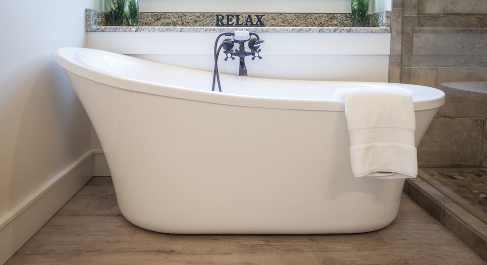 Example of a mid-sized transitional master beige tile and stone tile ceramic tile and beige floor freestanding bathtub design with raised-panel cabinets, gray cabinets, beige walls, an undermount sink, granite countertops and a hinged shower door