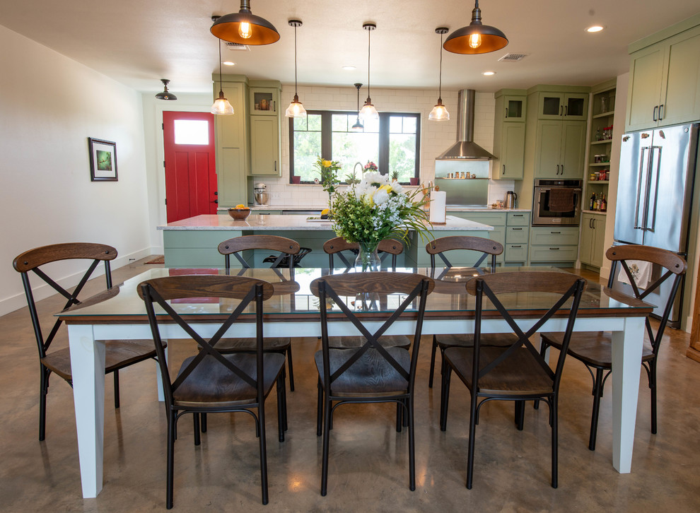 Large country open plan dining in Austin with white walls, concrete floors and brown floor.