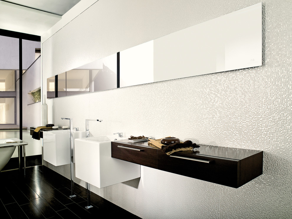 Photo of a contemporary bathroom in Perth with dark wood cabinets, a freestanding tub, white tile, ceramic tile, white walls, porcelain floors, a wall-mount sink and flat-panel cabinets.