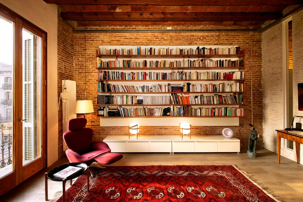 This is an example of a mid-sized industrial open concept family room in Barcelona with medium hardwood floors, a library, brown walls and no fireplace.