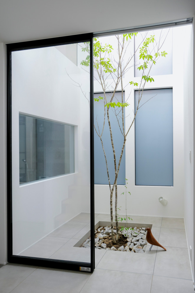 This is an example of a mid-sized modern courtyard patio in Other with a vertical garden, tile and no cover.