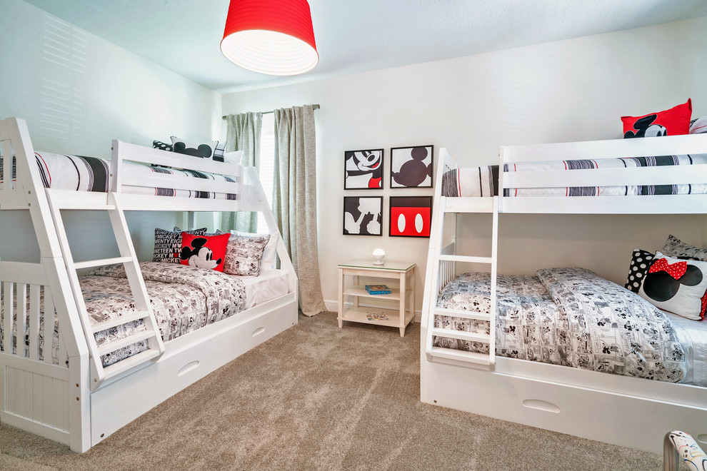 This is an example of a transitional gender-neutral kids' bedroom for kids 4-10 years old in Orlando with white walls, carpet and beige floor.