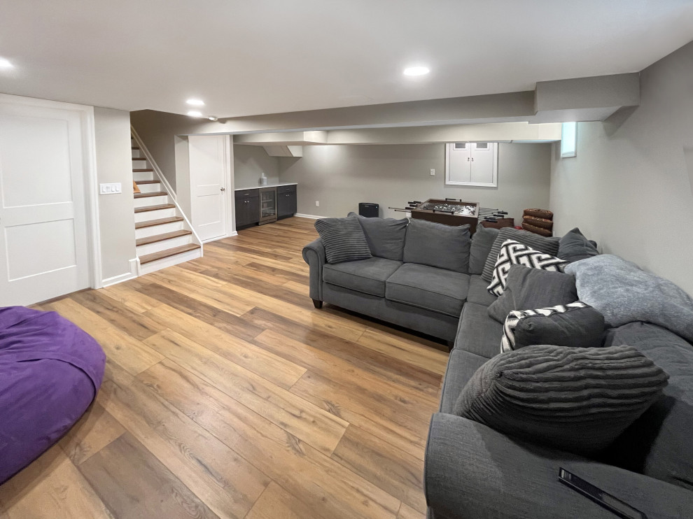 Large transitional fully buried basement in Philadelphia with grey walls, vinyl floors and brown floor.