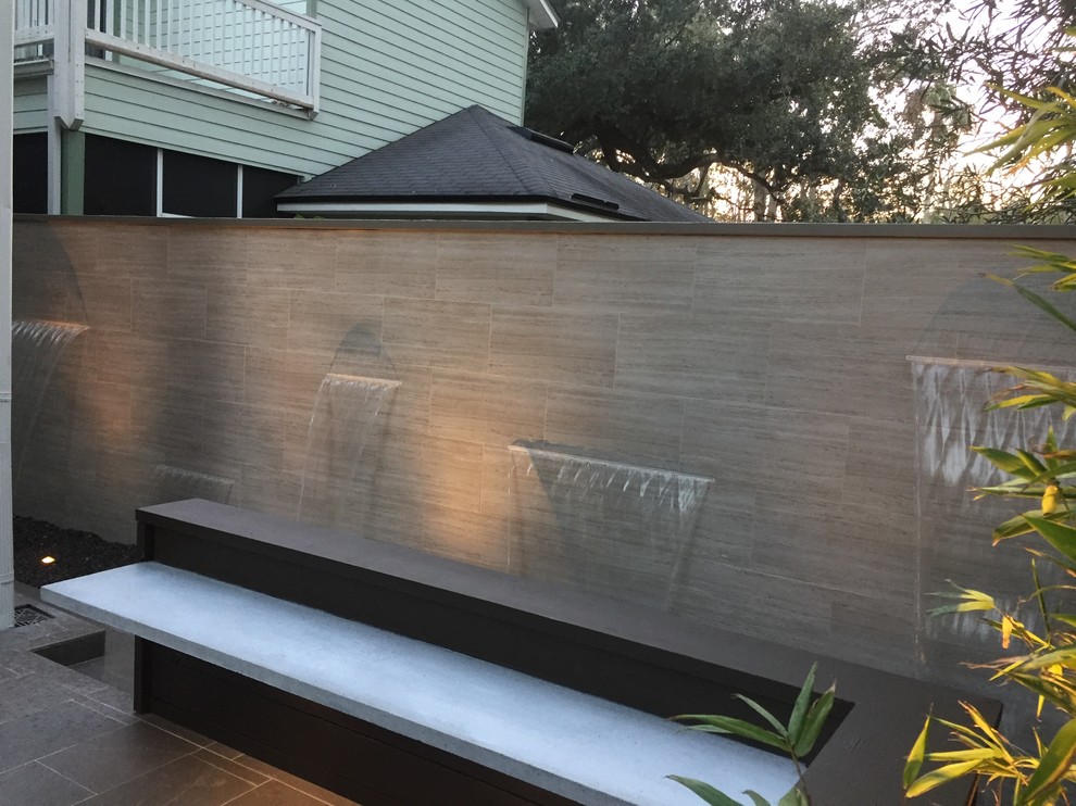 Small contemporary backyard patio in Jacksonville with a water feature, no cover and natural stone pavers.