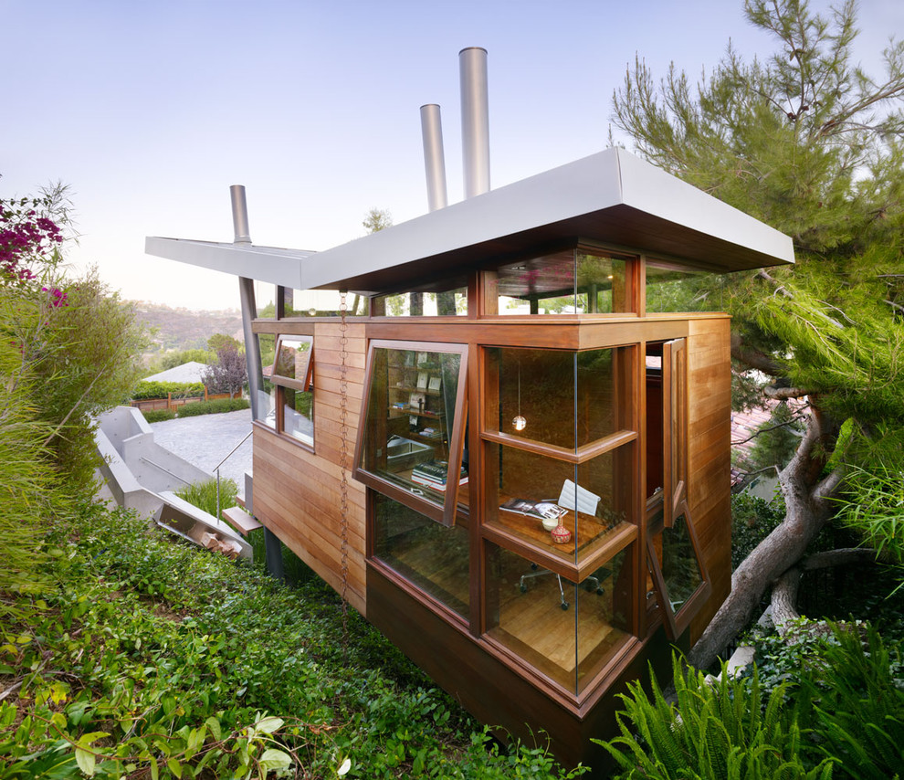 This is an example of a modern exterior in Los Angeles with wood siding and a butterfly roof.