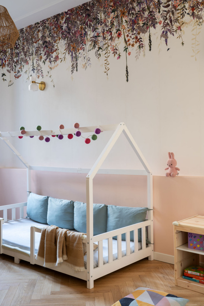 Aménagement d'une chambre d'enfant de 1 à 3 ans classique de taille moyenne avec un mur rose, parquet clair et du papier peint.