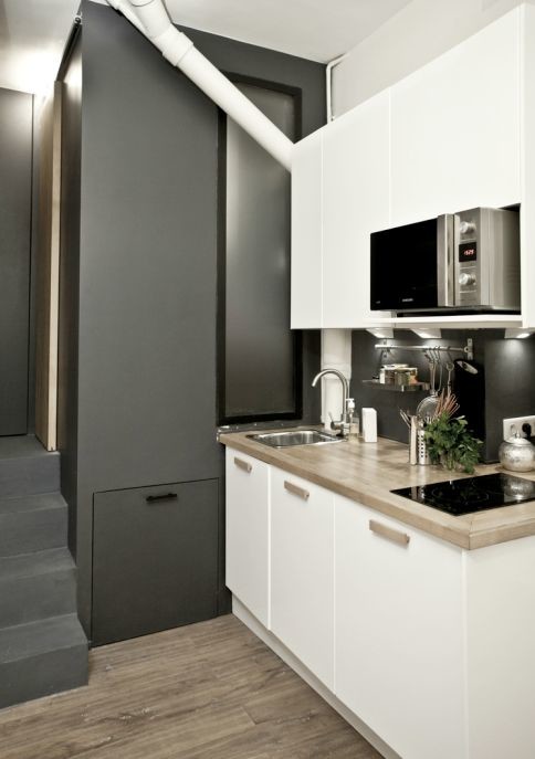 Mid-sized contemporary single-wall eat-in kitchen in Paris with white cabinets, medium hardwood floors and no island.