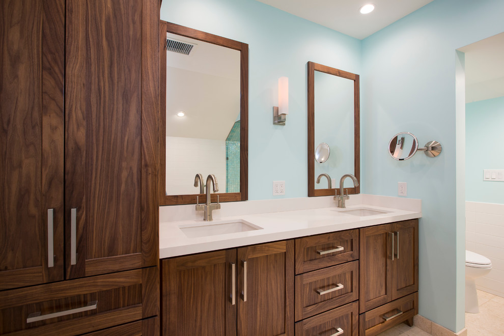 Design ideas for a mid-sized beach style master bathroom in Miami with shaker cabinets, dark wood cabinets, a freestanding tub, a corner shower, a one-piece toilet, multi-coloured tile, glass tile, blue walls, travertine floors, an undermount sink and engineered quartz benchtops.